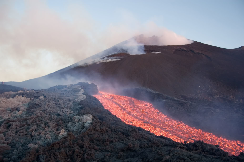 Lave en éruption volcanique à Sicile, lave rouge et fumée noire formant un spectacle naturel saisissant.